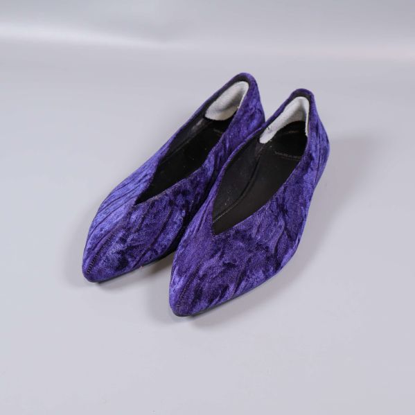 Par lila sammetsballerinor från sned vinkel