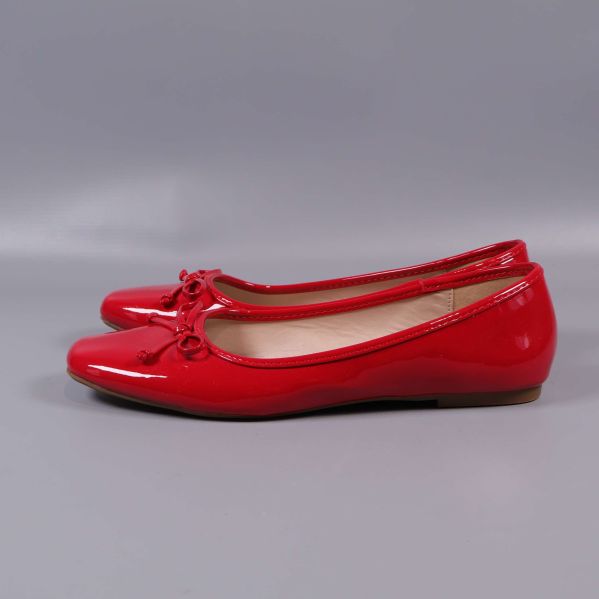 Röda ballerinas i profil med glansig yta