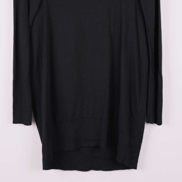 Närbild på nederdelen av svart lång klänning