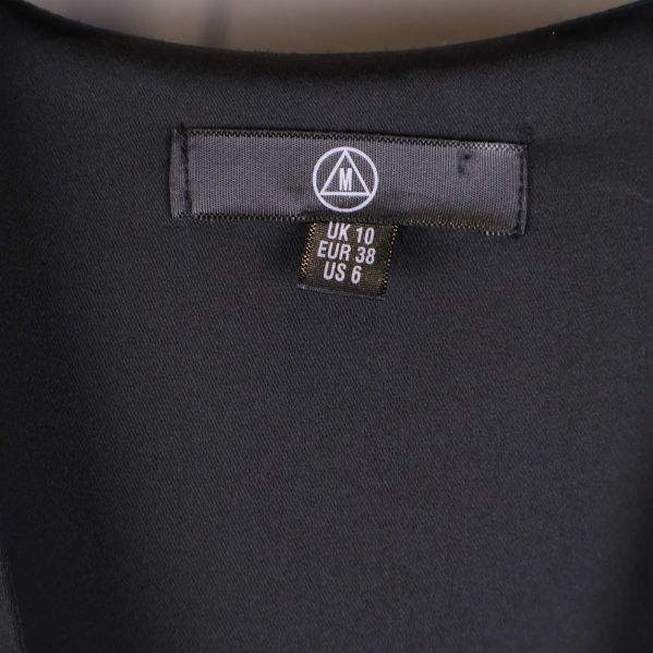 Storleksetikett för svart klänning visar EUR 38