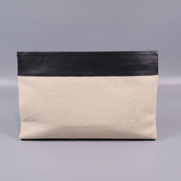 Clutchens baksida i beige canvas och svart kant