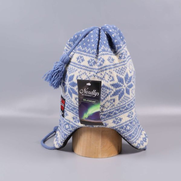 Baksida av blåvit stickad mössa med tofs och etikett