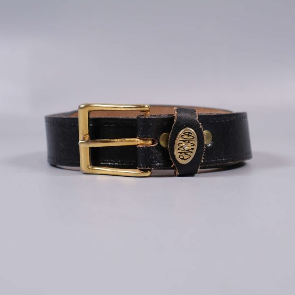 Svart bälte med guldfärgat spänne i fokus