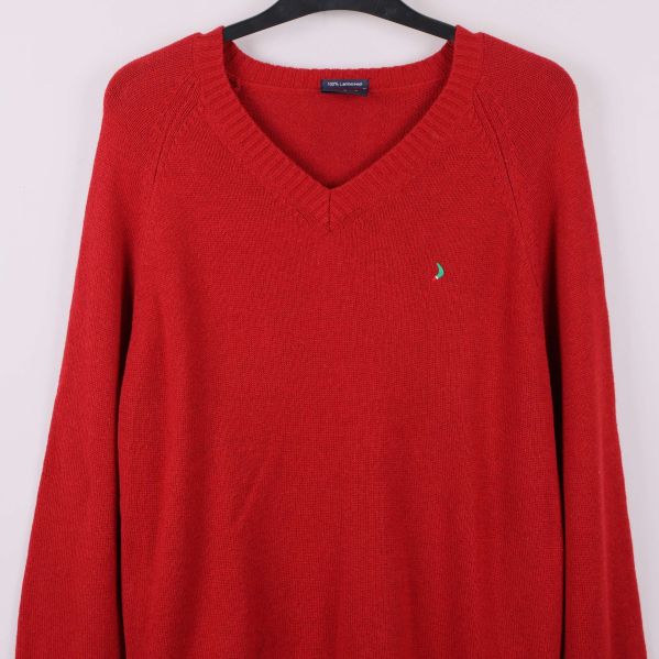 Närbild på bröstet med logga och v-ringad hals på röd tröja