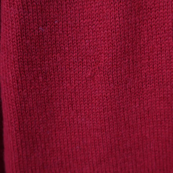 Materialstruktur på röd stickad tröja i närbild