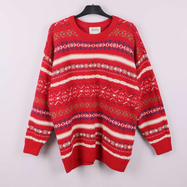 Röd stickad tröja med nordiskt flerfärgat mönster på galge