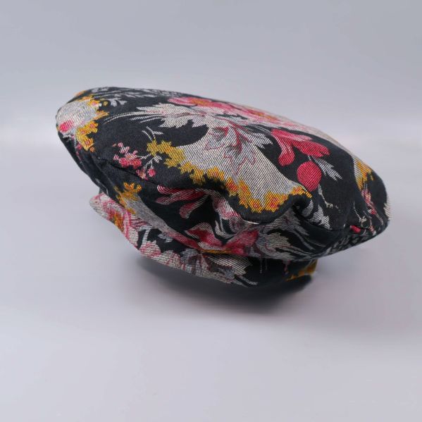 Basker i svart tyg med färgstarkt blommönster från sidan