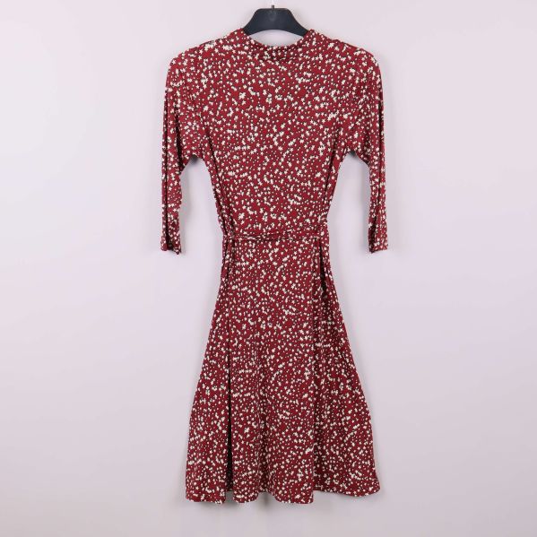 Röd klänning med stjärnmönster på galge bakifrån