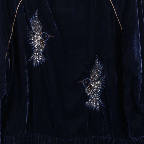 Närbild på broderade fåglar på jackans baksida