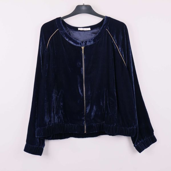 Blå sammetjacka med dragkedja på galge