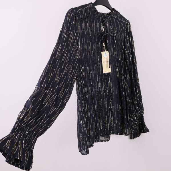 Blus med långa volangärmar i sidovy på galge