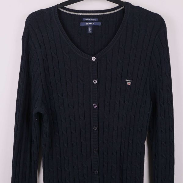 Framsida av cardigan med diskret logga på bröstet