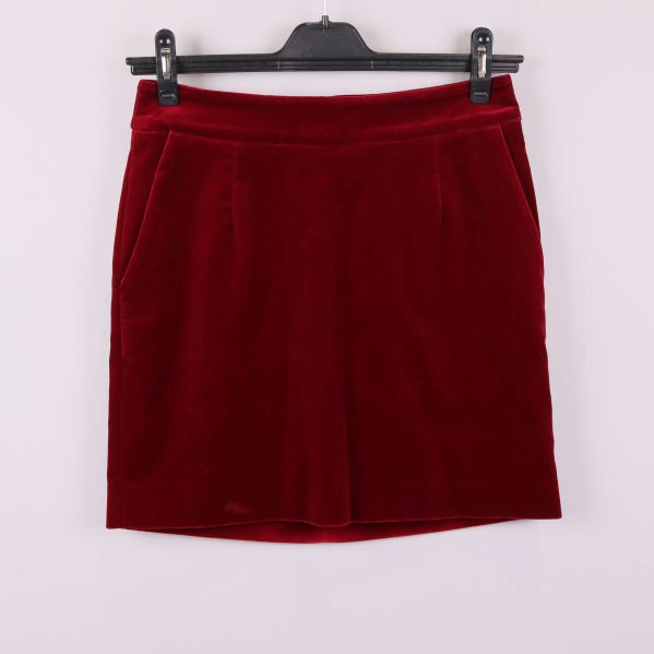 Framifrån: kort röd sammetskjol med fickor