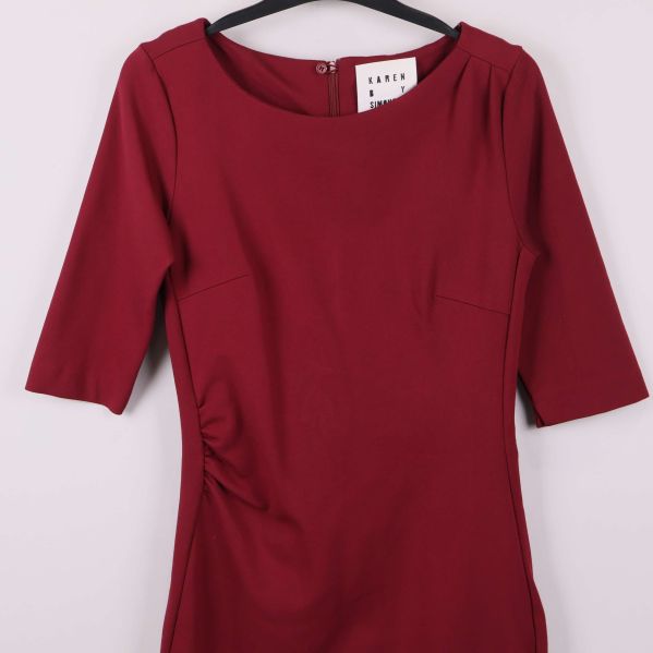 Närbild av överdel och drapering på vinröd klänning