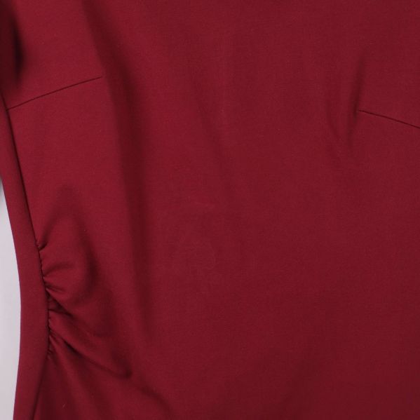 Närbild på vänster sida av klänningens tyg och drapering