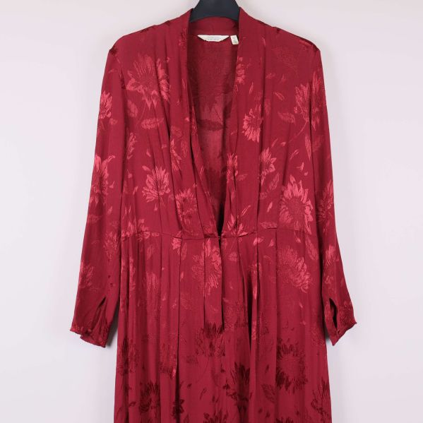 Övre del av vinröd klänning med djup krage och mönster