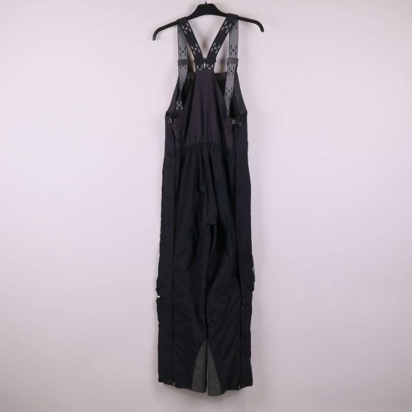 Bakre vy av svart hängselbyxa med elastisk rygg och axelband