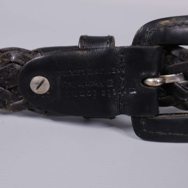 Präglad märkning på svart läder vid spännet