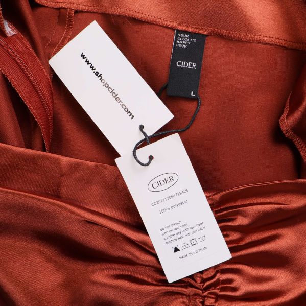 Etikett och tvättråd för kopparfärgad satinkjol från Cider