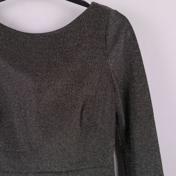 Detaljbild på överdelen av glittrig klänning