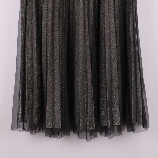 Närbild av fållen på svart plisserad midikjol med mesh