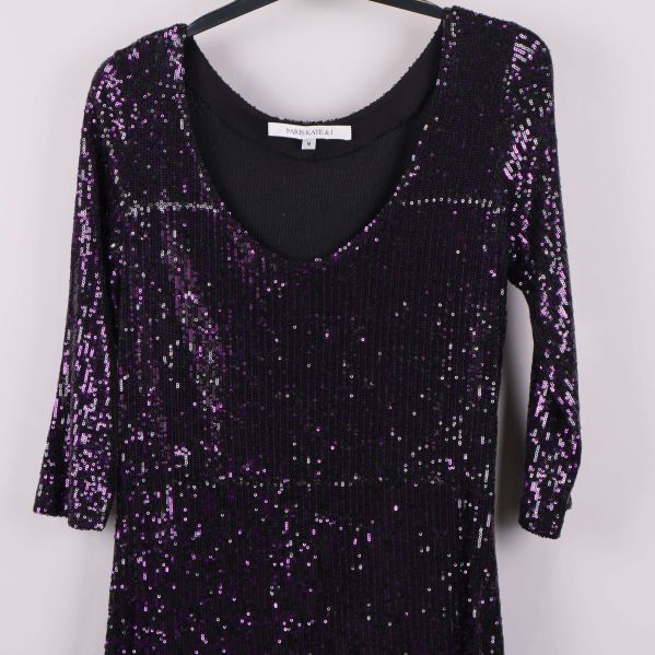 Överkropp och halsringning på klänning med lila paljetter