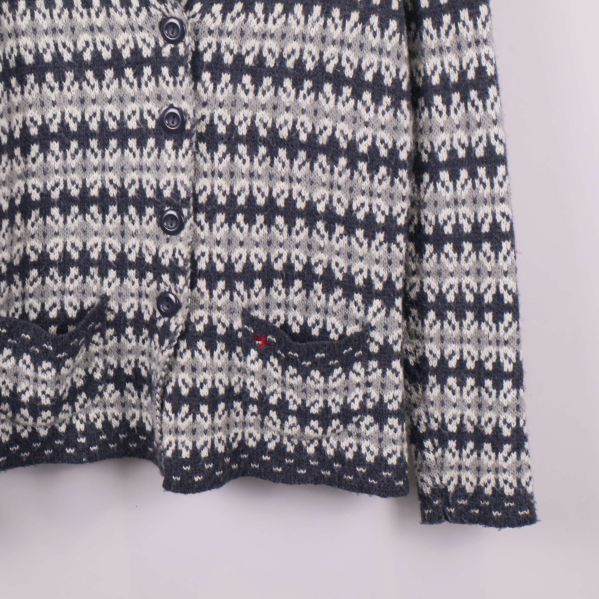 Närbild på koftans fickor med stickat mönster