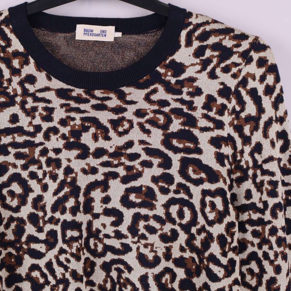 Närbild på tröjans leopardmönster och halslinning