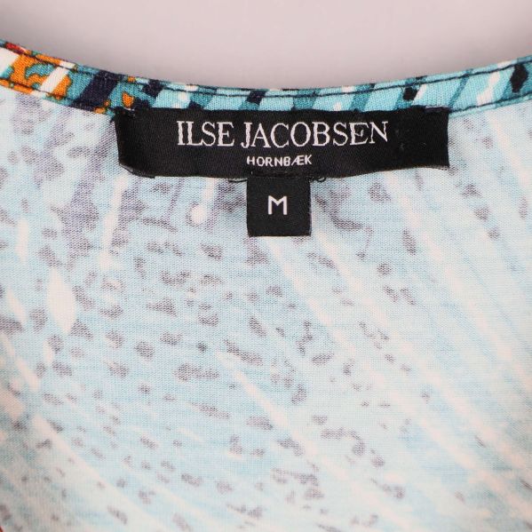 Närbild av Ilse Jacobsen-etikett i halsen på klänningen