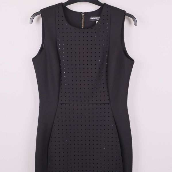 Övre delen av svart klänning med dekorstenar och ärmlös design