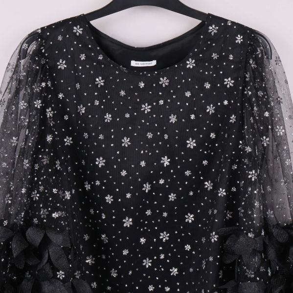 Närbild på toppen med glittermönster och rund halsringning