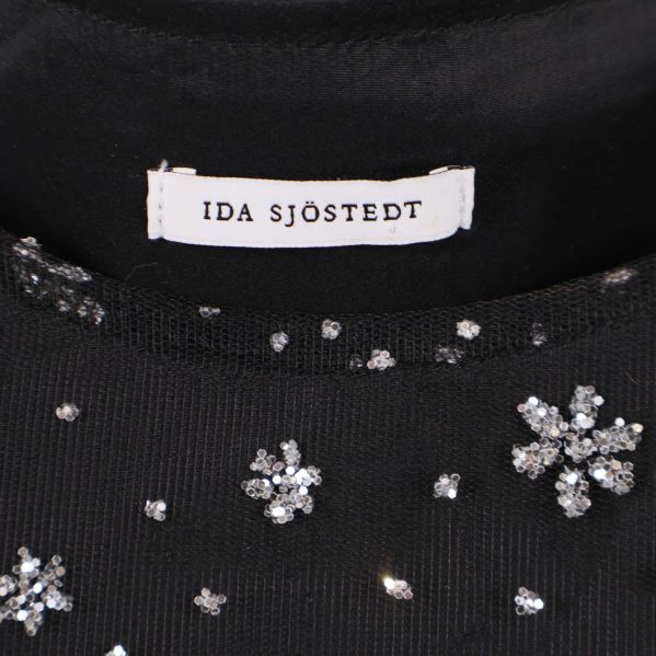 Närbild på Ida Sjöstedt etiketten i svart topp