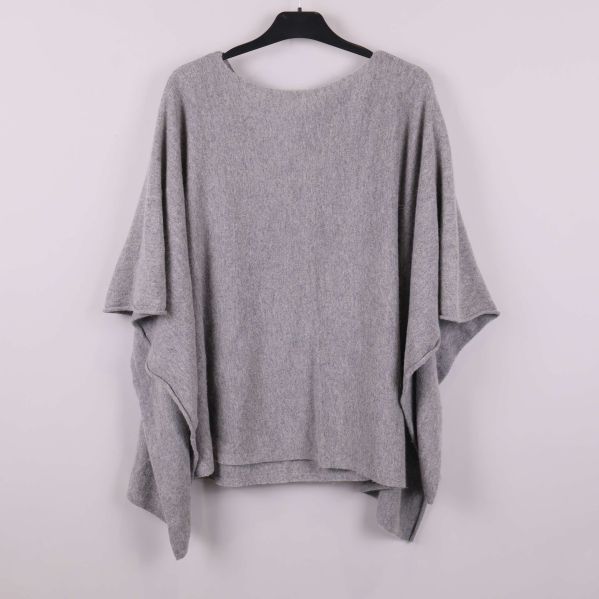 Ljusgrå poncho sedd bakifrån på galge