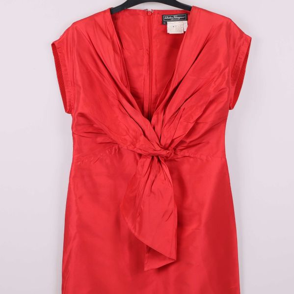 Närbild på röd klänning med veck och knyt framtill