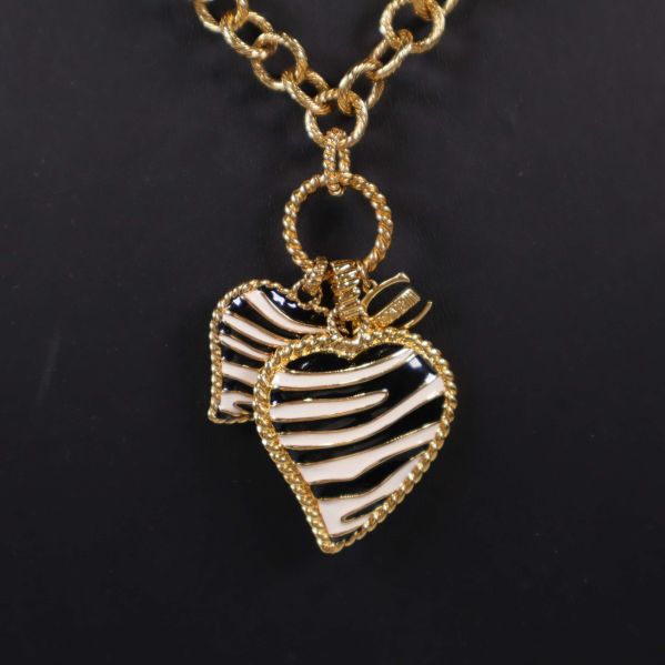 Närbild på två hjärtberlocker med zebraränder