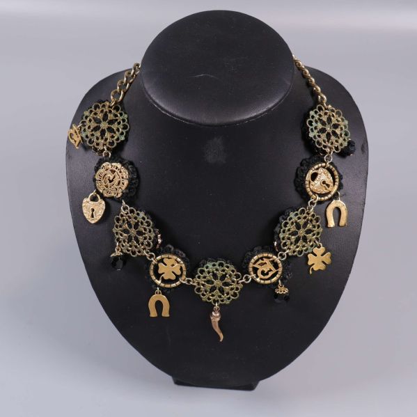 Närbild av halsbandet, visar gyllene kedja och lås