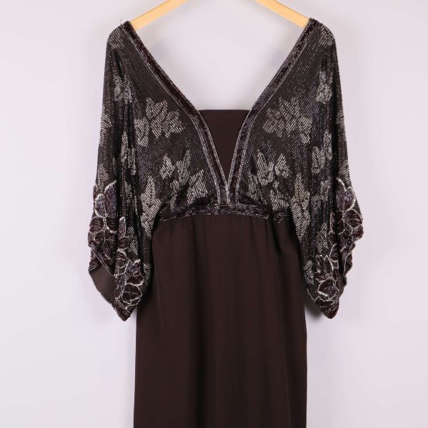 Närbild på klänningens dekorativa broderade ärmar