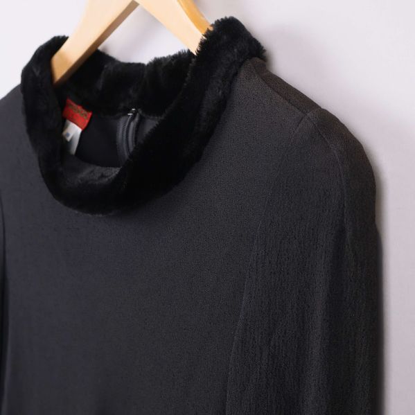 Närbild på krage med fuskpäls på svart tyg