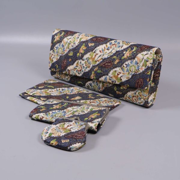 Väskset med clutch, plånbok och börs på grå bakgrund