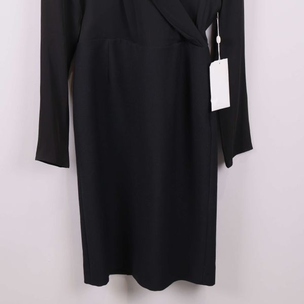 Närbild på nederdelen av svart långärmad omlottklänning