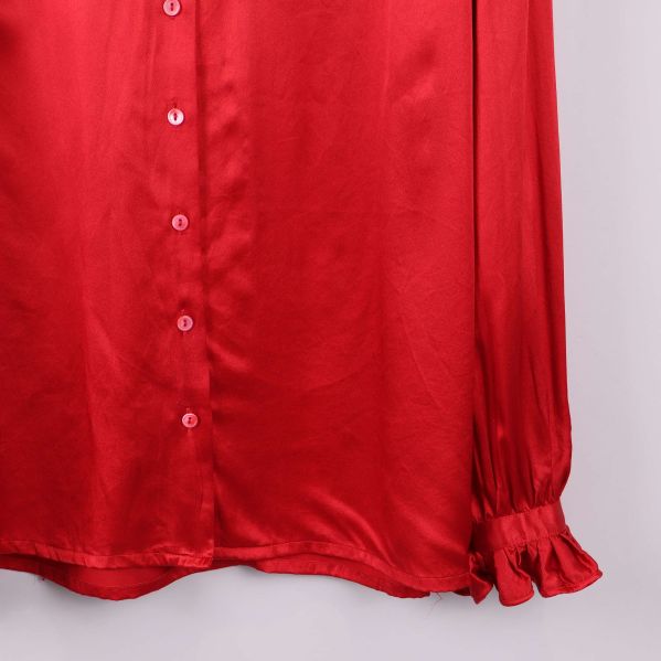 Närbild på ärmslut med volang och knappar