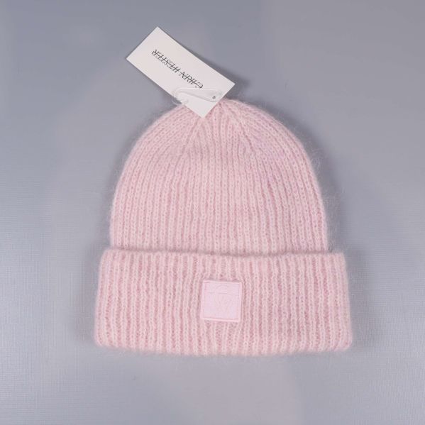 Ljusrosa ribbstickad mössa på grå bakgrund