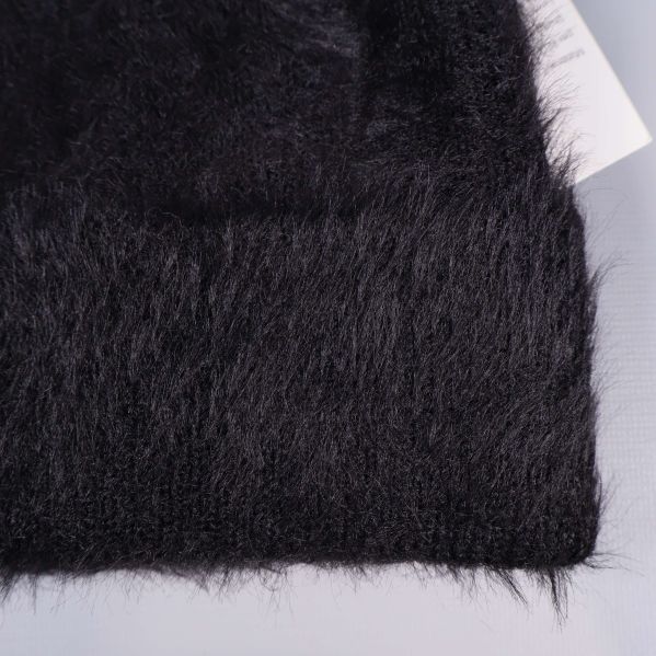 Närbild av mjuk luddig struktur på svart mössa