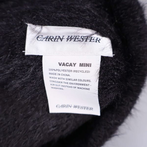 Närbild på Carin Wester-etikett inuti svart mössa