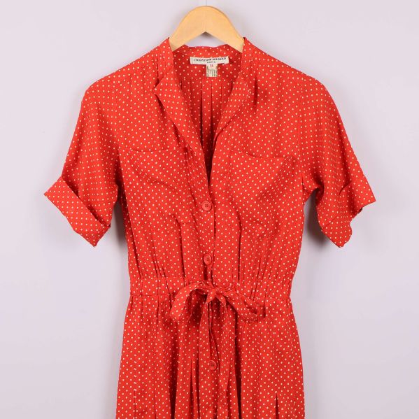 Närbild överdel av rödprickig klänning med knyt i midjan