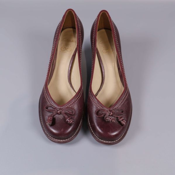 Pumps framifrån med dekorativa rosetter