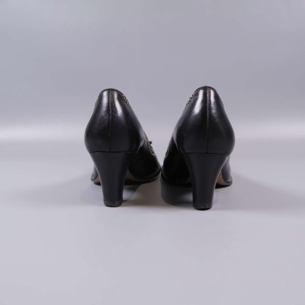 Baksida av svarta pumps med klackar mot kameran