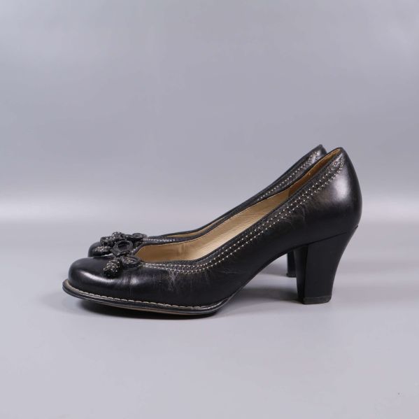 Profilvy av svarta pumps med klack på ljus bakgrund