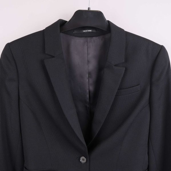 Närbild av krage, axlar och bröst på svart kavaj