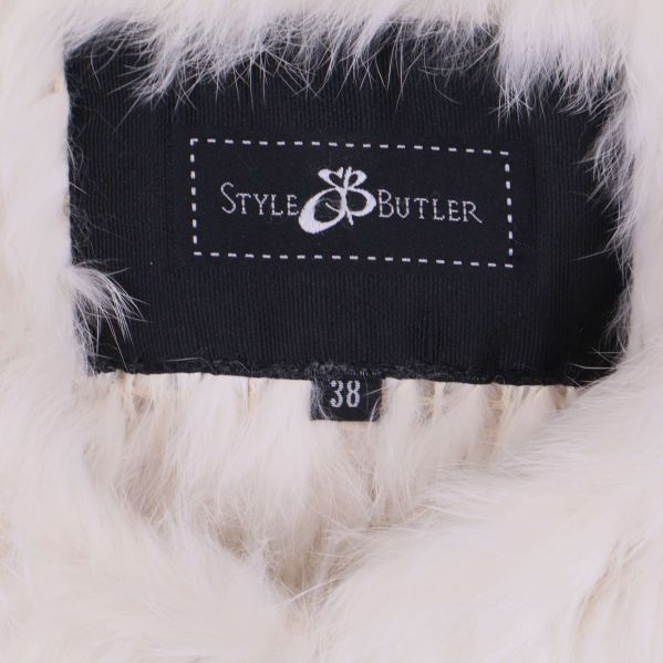 Närbild på Style Butler-märke och storleksetikett i västen